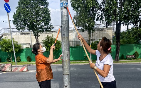Cán bộ phường tại TP.HCM đến từng nhà dân kêu gọi bóc quảng cáo dán bậy- Ảnh 4. Cột điện cũng là nơi bị dán bậy rất nhiều - Ảnh: CHÂU TUẤN