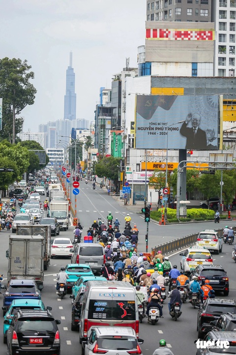 Nhiều nơi ở TP.HCM treo cờ rủ tưởng nhớ Tổng bí thư Nguyễn Phú Trọng- Ảnh 12. Tại các nút giao lớn, màn hình trình chiếu hình ảnh của Tổng bí thư Nguyễn Phú Trọng để người dân theo dõi