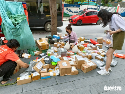 Kinh tế khó khăn, người Việt vẫn chi hàng trăm nghìn tỉ đồng mua sắm online- Ảnh 1. Người Việt ngày càng ưa chuộng mua sắm online, trong ảnh là shipper bày hàng để trả cho khách mua online - Ảnh: ĐỨC THIỆN