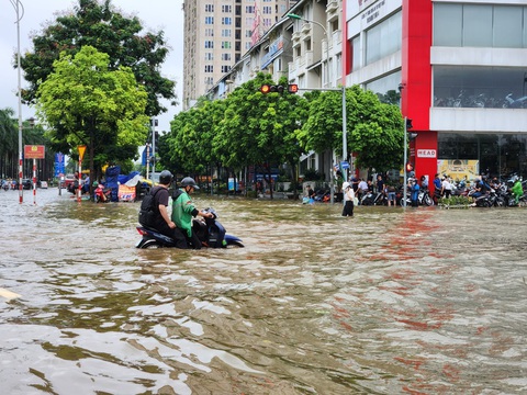 Đô thị mới phía tây Hà Nội chìm trong ‘biển’ nước mưa, chuyên gia nói gì?- Ảnh 4. Một tài xế Grab cố đưa khách vượt qua đoạn đường ngập sâu khoảng nửa mét - Ảnh: B.NGỌC