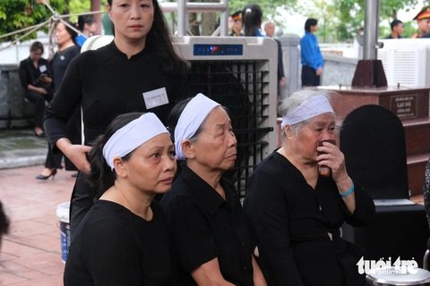 Người dân xếp hàng dài viếng Tổng Bí thư Nguyễn Phú Trọng ở Lại Đà- Ảnh 10. Bà Nguyễn Thị Dung (ngồi giữa), 78 tuổi, xóm 4, thôn Lại Đà, Đông Hội, Đông Anh, Hà Nội, dậy sớm chuẩn bị tang phục cùng con cháu đến viếng Tổng Bí thư Nguyễn Phú Trọng - Ảnh: HÀ QUÂN