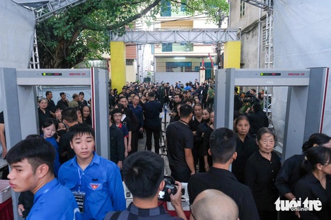 Người dân xếp hàng dài viếng Tổng Bí thư Nguyễn Phú Trọng ở Lại Đà- Ảnh 13. Người dân xếp hàng, kiểm tra lại tang phục trước cổng kiểm tra an ninh - Ảnh: HÀ QUÂN
