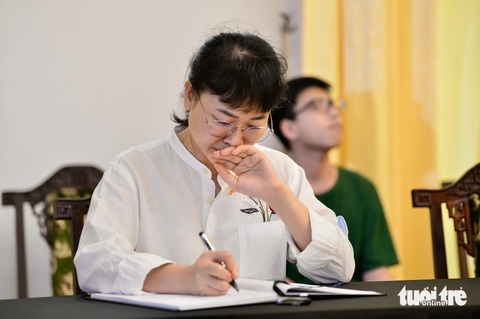 Chị Bùi Hồng Hà xúc động ghi những dòng sổ tang - Ảnh: QUANG ĐỊNH Lễ viếng Tổng Bí thư Nguyễn Phú Trọng tại Hội trường Thống Nhất: Nhớ nhà lãnh đạo đức độ, tài năng- Ảnh 24.