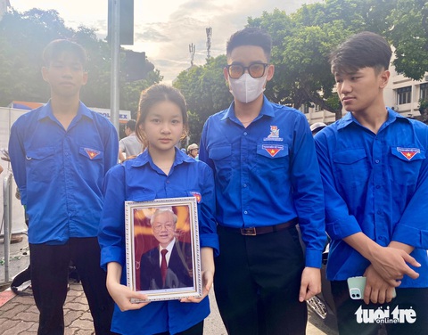Thủ đô Hà Nội trong ngày Quốc tang Tổng Bí thư Nguyễn Phú Trọng- Ảnh 4. Các bạn trẻ thủ đô mang theo di ảnh Tổng Bí thư xếp hàng vào viếng - Ảnh: HÀ THANH