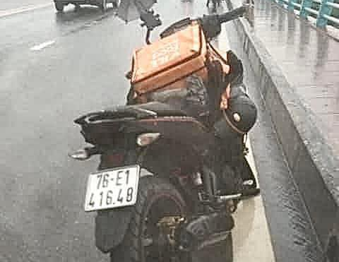 Thấy một phụ nữ nhảy cầu, shipper đang đi giao hàng lao xuống sông cứu người- Ảnh 2. Chiếc xe máy mà anh Vương đi giao hàng, lúc anh nhảy xuống sông cứu người, đơn hàng vẫn chưa kịp giao - Ảnh: Người dân cung cấp