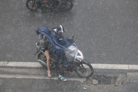 Mưa tạnh, trời Hà Nội hửng nắng trở lại- Ảnh 1. Cơn mưa dông kéo đến khiến việc di chuyển của người dân gặp khó - Ảnh: C.TUỆ