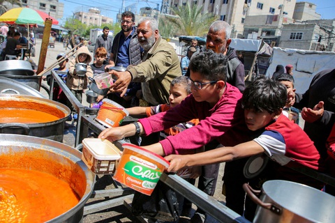Người dân Rafah, phía Nam Dải Gaza, nhận thực phẩm từ thiện - Ảnh: REUTERS Người dân Palestine ở thành phố Rafah, phía nam Dải Gaza, nhận thực phẩm từ thiện - Ảnh: REUTERS