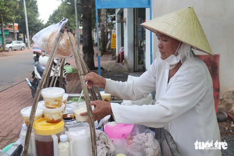 Gánh tàu hủ của cô Năm vẫn đều đặn hoạt động hơn 50 năm bất kể nắng mưa - Ảnh: THÙY LINH Cụ bà 70 tuổi bán tàu hủ nuôi con ăn học thành tài- Ảnh 1.