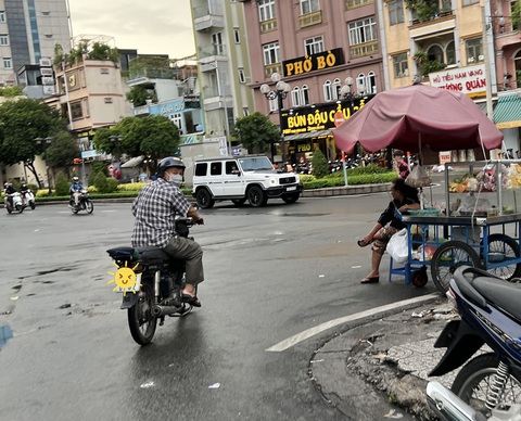 Đi theo chú nè, gác chân chống xe lên cháu ơi..., đời sao dễ thương quá đỗi!- Ảnh 1. Người đàn ông tốt bụng chỉ đường và dẫn chúng tôi từ hẻm ra đường Phan Xích Long (quận Phú Nhuận, TP.HCM) - Ảnh: YẾN TRINH