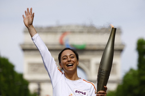 Lễ khai mạc Olympic Paris 2024 được giữ kín như bí mật quốc gia- Ảnh 1. Nữ đầu bếp trẻ của Pháp Nina Metayer được vinh dự tham gia rước đuốc Thế vận hội trước Khải hoàn môn ở thủ đô Paris - Ảnh: REUTERS