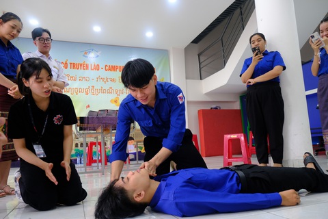 Sinh viên y khoa biên soạn, tặng cộng đồng hơn 2.000 cẩm nang sơ cấp cứu- Ảnh 2. Các bạn lưu học sinh Lào được hướng dẫn sơ cấp cứu ban đầu - Ảnh: NGỌC PHƯỢNG
