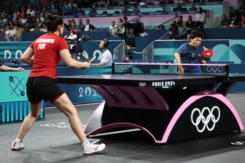 Nữ VĐV bóng bàn lớn tuổi nhất Ni Xia Lian vào vòng 2 Olympic 2024- Ảnh 1. Bà Ni Xia Lian (phải) đánh bại Sibel Altinkaya tại Olympic 2024