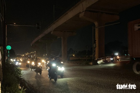 Đèn chiếu sáng song hành xa lộ Hà Nội không hoạt động, người dân vừa đi đường vừa run- Ảnh 2. Người dân đi qua đoạn đường này phải giảm tốc, bật đèn pha sáng để nhìn đường - Ảnh: TIẾN QUỐC