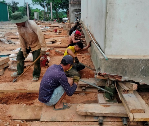 ‘Thần đèn’ dùng cách gì để dời 3 căn nhà tại Quảng Bình?- Ảnh 2. Sau khi cắt móc, lực lượng nhân công dùng kích thủy lực nâng ngôi nhà hàng trăm tấn lên để chèn ray trượt bên dưới - Ảnh: NGỌC THẢO