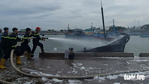 4 tàu cá bất ngờ bốc cháy khi đang neo đậu ở cảng Ninh Chữ- Ảnh 2. Lực lượng cảnh sát phòng cháy chữa cháy và cứu nạn cứu hộ Công an tỉnh Ninh Thuận nỗ lực dập tắt đám cháy - Ảnh: DUY NGỌC