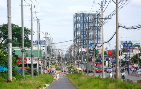 Các cột điện trên quốc lộ 13 đoạn qua thành phố Thuận An, tỉnh Bình Dương đang được di dời để bàn giao mặt bằng mở rộng thêm hai làn xe (ảnh chụp tháng 7-2024) Bình Dương chủ động 'giải cứu' tiến độ quốc lộ 13- Ảnh 1.