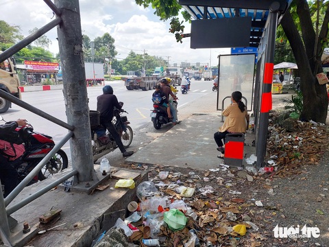 Trạm xe buýt ở TP.HCM thành nơi đổ rác, cơ quan quản lý nói gì?- Ảnh 2. Giữa trưa nắng, những túi rác bốc mùi hôi thối khiến ai đi ngang cũng khó chịu - Ảnh: ĐÌNH KHẢI