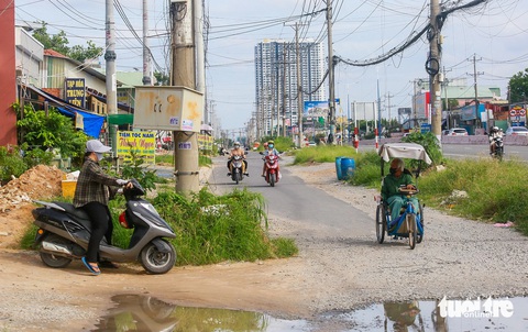 Quốc lộ 13 Bình Dương đã mở rộng nhưng vẫn nằm chờ di dời lưới điện- Ảnh 2. Quốc lộ 13 Bình Dương đã mở rộng nhưng vẫn nằm chờ di dời lưới điện- Ảnh 2.