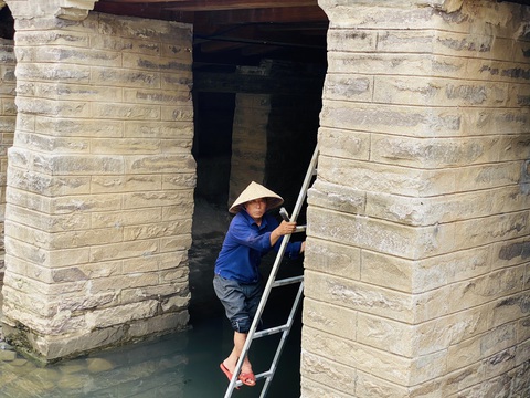Chùa Cầu Hội An đã 'bớt trẻ', khách bắt đầu đổ về tham quan- Ảnh 2. Công nhân chỉnh sửa các đường nét nhỏ, cọ rửa vệ sinh chuẩn bị cho lễ khánh thành - Ảnh: B.D.
