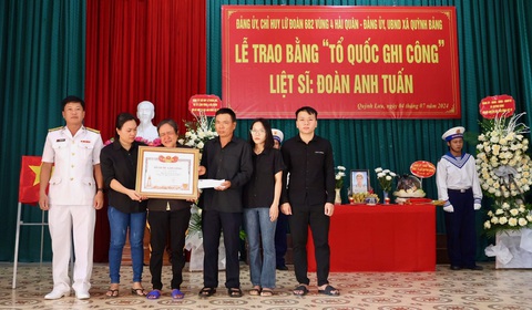 Trao bằng Tổ quốc ghi công cho 3 liệt sĩ hy sinh ở quần đảo Trường Sa- Ảnh 2. Gia đình liệt sĩ Đoàn Anh Tuấn xúc động nhận bằng Tổ quốc ghi công - Ảnh: TUYÊN BỐN