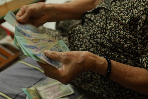 Căn nhà nhỏ của bà không có cửa sổ, chỉ có lối ra vào, ánh sáng trong nhà hơi tối do bóng điện cũ. Lựa một góc sáng, bà Tâm tranh thủ đếm lại tiền lương hưu vừa lãnh về. Số tiền không nhiều nhưng đủ để trả tiền thuốc chữa tiểu đường, áp huyết, mỡ máu - Ảnh: HOA NGUYỄN Hầu hết người hưởng lương hưu đã chuyển từ phương thức nhận tiền mặt sang nhận qua tài khoản - Ảnh: HOA NGUYỄN