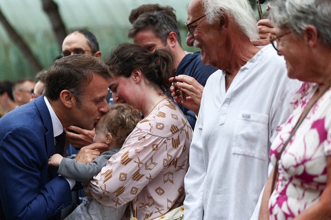 Ông Macron vắng bóng trước công chúng gần 2 tuần- Ảnh 3. Tổng thống Pháp hôn lên trán một em bé trong buổi giao lưu với những người ủng hộ ông sau cuộc bỏ phiếu vòng đầu tiên ngày 30-6 - Ảnh: AFP