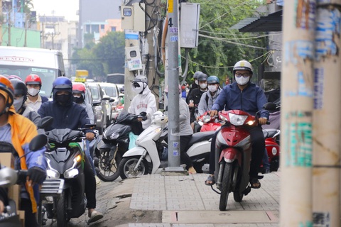 Đề xuất làm đường trên cao trên quốc lộ 13 qua Đinh Bộ Lĩnh, Xô Viết Nghệ Tĩnh- Ảnh 4. Vào khoảng 8h sáng hằng ngày, tình trạng kẹt xe thường xuyên diễn ra, nhiều người phải leo lề để vượt qua quãng kẹt - Ảnh: TIẾN QUỐC