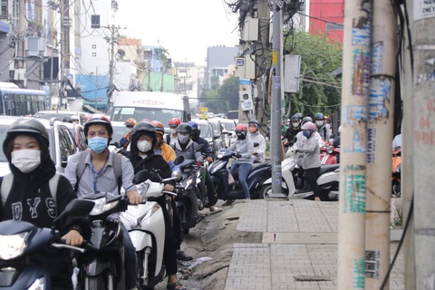 Đề xuất làm đường trên cao trên quốc lộ 13 qua Đinh Bộ Lĩnh, Xô Viết Nghệ Tĩnh- Ảnh 5. Vì tình trạng kẹt xe thường xuyên, nhiều người phải leo lề để vượt qua quãng kẹt - Ảnh: TIẾN QUỐC