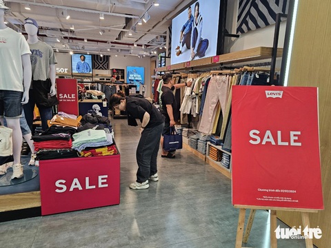 Thời trang giảm giá 'sập sàn', 100.000 đồng đã mua được áo hiệu- Ảnh 1. Nhiều thương hiệu lớn tại trung tâm thương mại Vincom Center (quận 1) tung khuyến mãi khủng - Ảnh: NHẬT XUÂN