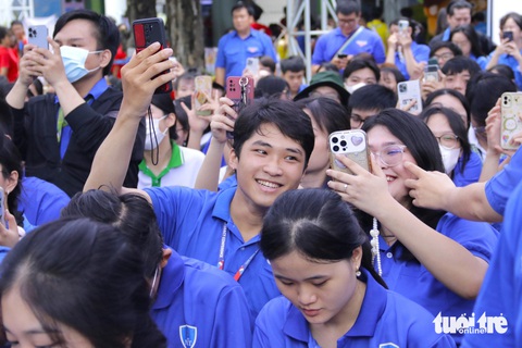Phó bí thư Thành Đoàn TP.HCM: Hy vọng xã đảo Thạnh An sẽ sớm có tàu cấp cứu hiện đại- Ảnh 5. Chiến sĩ tình nguyện giơ cao điện thoại quét mã QR để quyên góp cho chương trình - Ảnh: TIẾN QUỐC