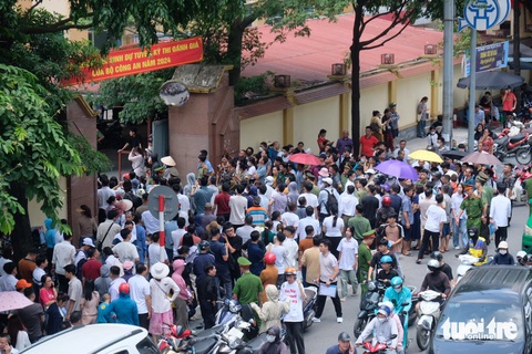 Thi đánh giá vào các trường công an: 'Đề thi văn khá lạ'- Ảnh 7. Tại điểm thi Học viện An ninh nhân dân, phụ huynh đội nắng đứng chật kín trước cổng điểm thi chờ thí sinh ra - Ảnh: NGUYÊN BẢO