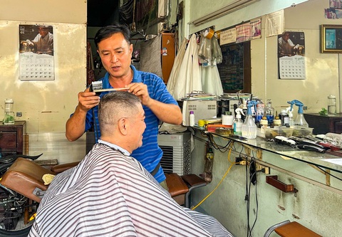 Chủ tiệm hớt tóc Nguyễn Văn Thắng đang hớt tóc cho khách tại khu chợ Ga - Ảnh: PHAN NGUYỄN QUỲNH TRÂM Chủ tiệm hớt tóc Nguyễn Văn Thắng đang hớt tóc cho khách tại khu chợ Ga - Ảnh: PHAN NGUYỄN QUỲNH TRÂM