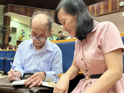 Thầy giáo 87 tuổi thi đỗ thạc sĩ, được trường tặng học bổng- Ảnh 2. Ông Thành có thói quen ký tặng những quyển sách của mình cho mọi người. Trong ảnh: Ông Thành ký tặng sách cho TS Bùi Thanh Thảo, trưởng khoa khoa học xã hội và nhân văn (Trường đại học Cần Thơ), trong lễ khai giảng - Ảnh: LAN NGỌC