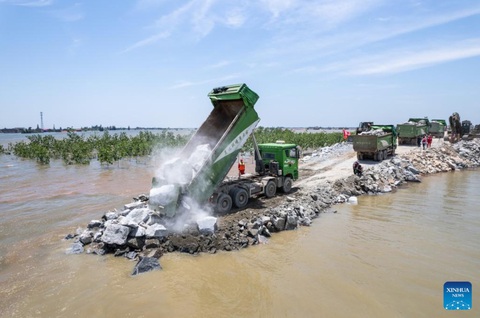 Trung Quốc dốc lực khẩn trương vá đê hồ Động Đình- Ảnh 2. Ước tính khoảng 10.000 tấn cát đá và 18 xe tải đã được triển khai, cố gắng bịt kín đoạn đê bị vỡ trong những ngày qua - Ảnh: TÂN HOA XÃ