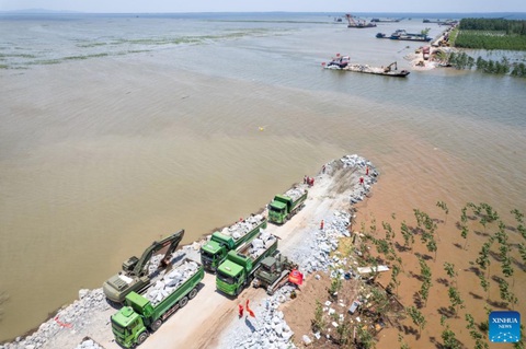 Trung Quốc dốc lực khẩn trương vá đê hồ Động Đình- Ảnh 6. Tính đến chiều 7-7, lực lượng cứu hộ đã sử dụng sỏi, đá và các vật liệu khác để lấp khoảng 87m trên đoạn đê nứt tại hồ Động Đình - Ảnh: TÂN HOA XÃ