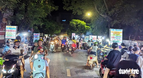 Hàng rong tràn xuống phố, chính quyền ‘bó tay’ vì lực lượng mỏng?- Ảnh 1. Đoạn đường Hoàng Hoa Thám gần sông Hương ở TP Huế bị hàng chục xe đẩy bán hàng rong chiếm dụng sau 10h tối - Ảnh: NHẬT LINH