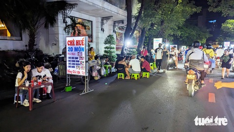 Hàng rong tràn xuống phố, chính quyền ‘bó tay’ vì lực lượng mỏng?- Ảnh 2. Lòng đường trở thành nơi bày bàn ghế của những xe đẩy bán hàng rong sau 10h tối - Ảnh: NHẬT LINH