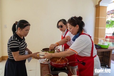 Tình nguyện viên Hàn Quốc 'chữa lành' trẻ em khuyết tật Quảng Trị- Ảnh 3. Người dân địa phương nhận món ăn truyền thống của Hàn Quốc tại Trại chữa lành - Ảnh: HOÀNG TÁO