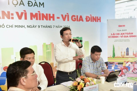 Lái xe an toàn: Giải quyết 'gốc rễ' từ ý thức mỗi người- Ảnh 1. Nhà báo Trần Xuân Toàn (giữa), phó tổng biên tập báo Tuổi Trẻ, phát biểu mở đầu buổi tọa đàm “Lái xe an toàn: Vì mình - vì gia đình” - Ảnh: T.T.D