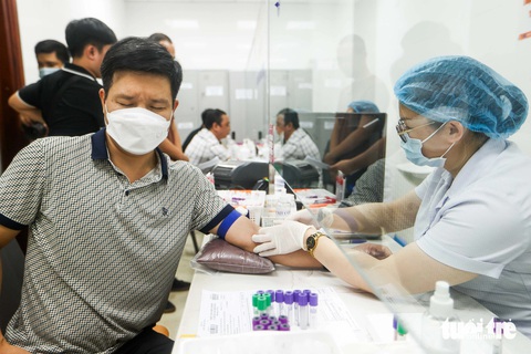 Một bệnh nhân đang lấy máu xét nghiệm - Ảnh: NGUYỄN KHÁNH Một bệnh nhân lấy máu xét nghiệm trong ca khám tối 1-8 - Ảnh: NGUYỄN KHÁNH