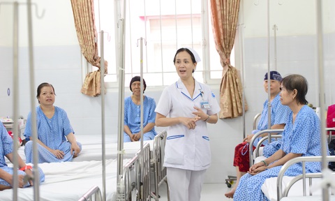 Điều dưỡng viên tại một bệnh viện ở TP.HCM trò chuyện, động viên các bệnh nhân - Ảnh: DUYÊN PHAN Làm sao hết 'khát' điều dưỡng?- Ảnh 1.