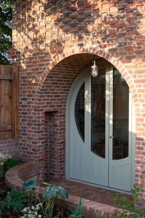 Ngôi nhà bằng gạch thủ công - điểm nhấn lạ lùng ở Peckham, London- Ảnh 3. Vòm cửa ra vào sau nhà - Ảnh: dwell