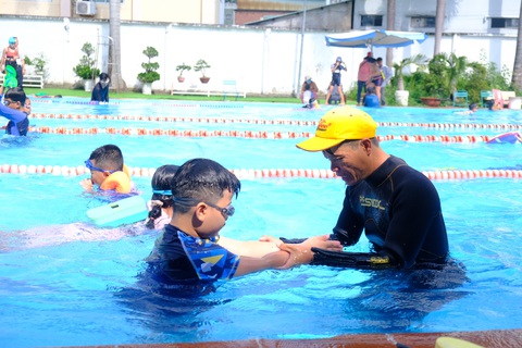 Lớp học bơi miễn phí cho trẻ khó khăn ở Thủ Đức- Ảnh 1. Huấn luyện viên đang hướng dẫn học viên các động tác cơ bản - Ảnh: NGỌC PHƯỢNG