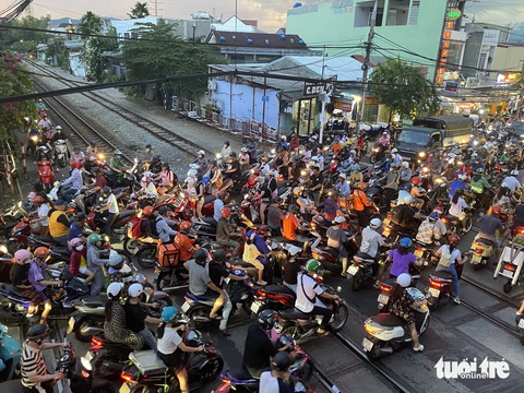 Dừng xe chờ tàu hỏa tràn sang cả làn ngược chiều, có nhanh hơn không?- Ảnh 3. Dòng xe đến từ tứ phía, lao vào nhau khi tàu hỏa đi qua - Ảnh: LỆ XUÂN
