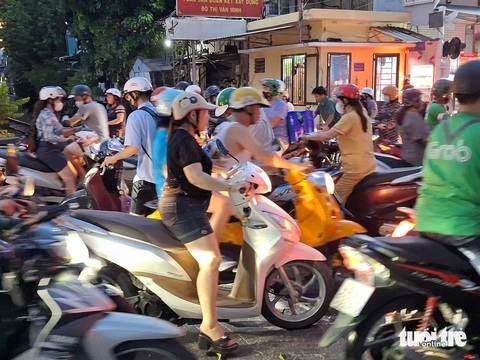 Dừng xe chờ tàu hỏa tràn sang cả làn ngược chiều, có nhanh hơn không?- Ảnh 4. Đám đông xe máy hỗn loạn lao vào nhau gây xung đột giao thông tại đoạn chờ tàu hỏa - Ảnh: PHẠM HOÀI