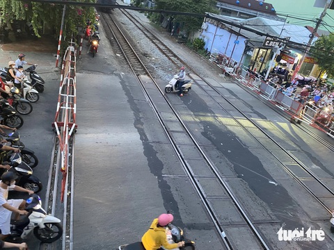 Dừng xe chờ tàu hỏa tràn sang cả làn ngược chiều, có nhanh hơn không?- Ảnh 7. Cố gắng luồn vào bên trong gác chắn tàu để lát nữa đi