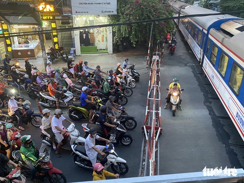 Dừng xe chờ tàu hỏa tràn sang cả làn ngược chiều, có nhanh hơn không?- Ảnh 8. Chở theo con nhỏ nhưng bất chấp nguy hiểm - Ảnh: TI NA