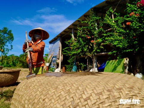 Làng nghề thúng chai với 'tuyệt chiêu' chống thấm bằng... phân bò- Ảnh 8. Thúng chai được quét dầu rái để chống thấm - Ảnh: MINH CHIẾN