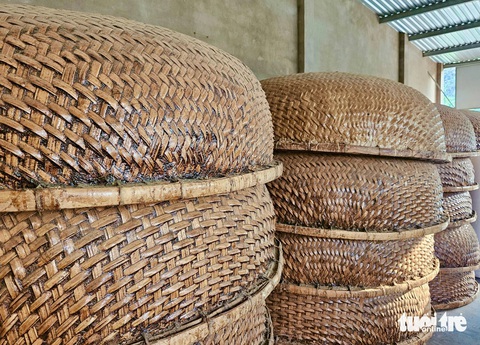 Làng nghề thúng chai với 'tuyệt chiêu' chống thấm bằng... phân bò- Ảnh 9. Thúng chai xếp chồng lên nhau có màu nâu óng như sáp ong - Ảnh: MINH CHIẾN
