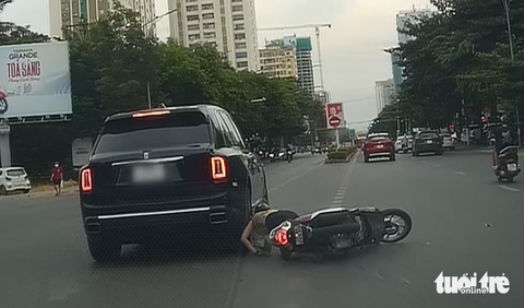 Siêu xe Rolls-Royce xi nhan trái nhưng đi thẳng, suýt gây tai nạn- Ảnh 1. Cô gái ngã xuống đường khi chiếc xe Rolls-Royce xi nhan trái nhưng bất ngờ đi thẳng - Ảnh: DOÃN HÒA
